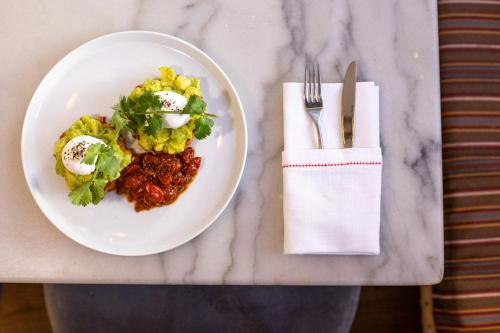 a plate of food on a table with a fork and knife at Artist Residence London in London