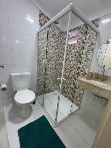 a bathroom with a shower with a toilet and a green rug at Casa Lanôh in Canindé de São Francisco