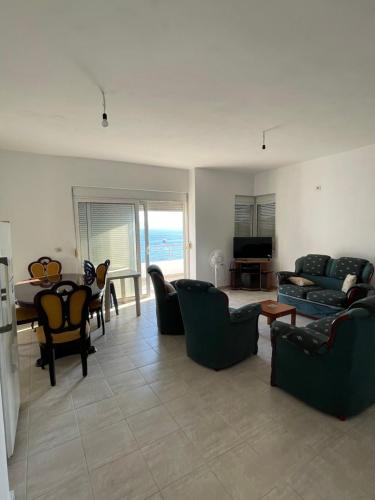 ein Wohnzimmer mit Sofa, Stühlen und einem Tisch in der Unterkunft Lilis Apartments Sea view in Sarandë
