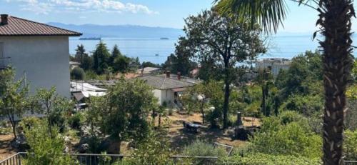 a view of a yard with trees and a house at Apartmani ViVa in Lovran