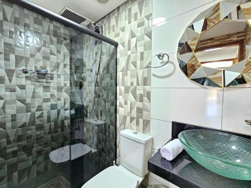 a bathroom with a sink and a glass shower at Casa 2 quartos 2 banheiros em meio a Área Verde in Foz do Iguaçu