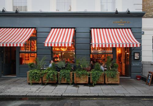 a restaurant with red and white striped awnings in front at Artist Residence London in London