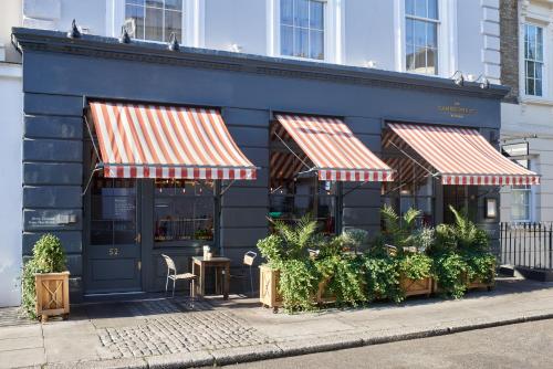 a restaurant with two awnings on the side of a building at Artist Residence London in London