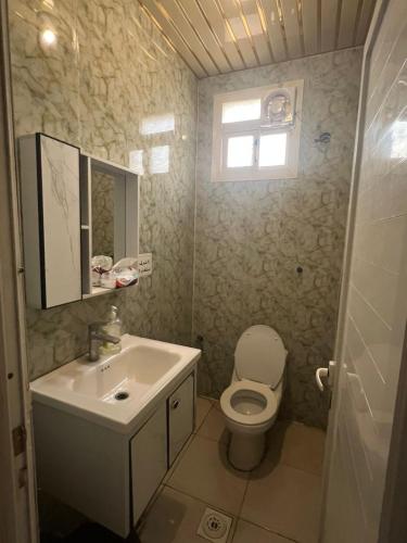 a bathroom with a sink and a toilet and a window at Al Majaridah Hotel in Al Majaridah