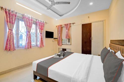 a bedroom with a bed and a tv and windows at Super Capital O New All In One Near City Centre Salt Lake in Kolkata