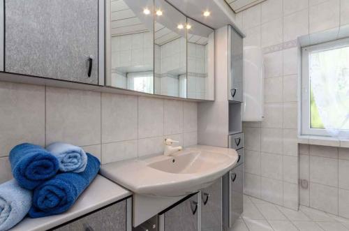 a bathroom with a sink and a mirror and towels at One-Bedroom Apartment in Crikvenica IX in Sopaljska