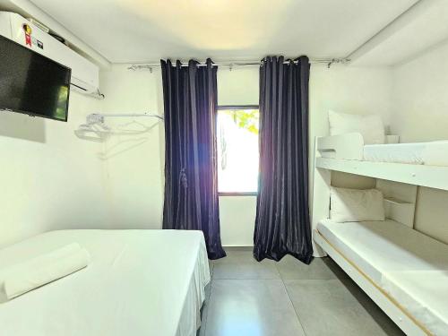 a bedroom with two beds and a window at Casa 2 quartos 2 banheiros em meio a Área Verde in Foz do Iguaçu