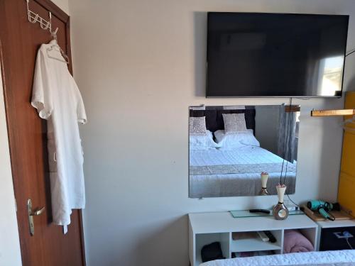 a small bedroom with a bed and a mirror at Quarto em Tijucas in Tijucas