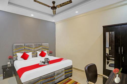 a bedroom with a large bed with red pillows at Hotel O Sunshine in Kalkaji Devi