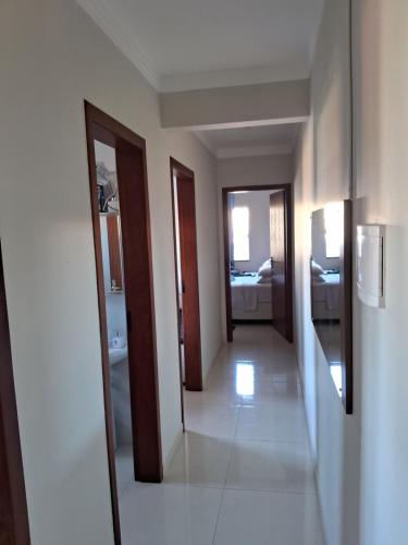 a hallway with two doors and a room with a bathroom at Quarto em Tijucas in Tijucas