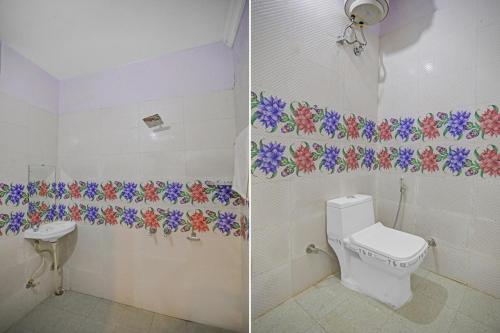a bathroom with a toilet and flowers on the wall at Hotel O Sunshine in Kalkaji Devi