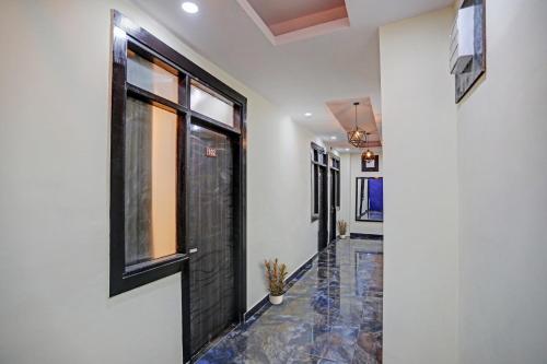 a hallway with a black door and a tile floor at Hotel O Sunshine in Kalkaji Devi