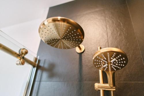 a bathroom with two mirrors and a shower at Hôtel Château Cran Chaud in Saguenay
