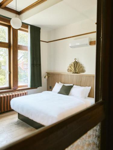 a bedroom with a large white bed and a window at Hôtel Château Cran Chaud in Saguenay