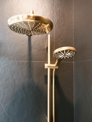 a shower with a shower head in a bathroom at Hôtel Château Cran Chaud in Saguenay