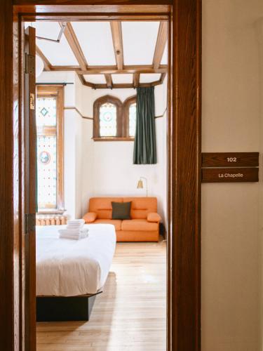 a bedroom with a bed and a couch in a room at Hôtel Château Cran Chaud in Saguenay
