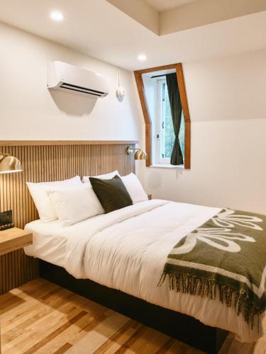 a bedroom with a large bed and a window at Hôtel Château Cran Chaud in Saguenay