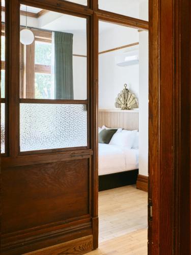 a door leading to a bedroom with a bed at Hôtel Château Cran Chaud in Saguenay
