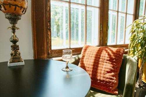 a table with a wine glass on top of it at Hôtel Château Cran Chaud in Saguenay