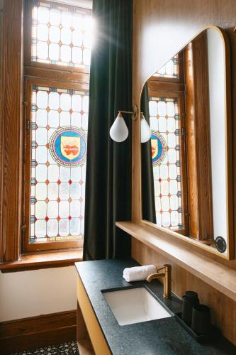 a bathroom with a sink and a mirror at Hôtel Château Cran Chaud in Saguenay