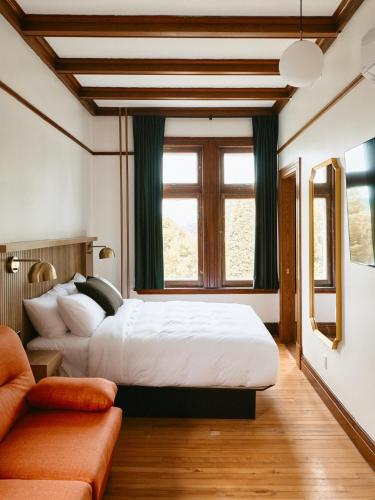 a bedroom with two beds and a couch at Hôtel Château Cran Chaud in Saguenay