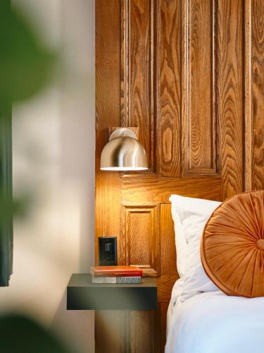 a bedroom with a wooden headboard and a bed with a table at Hôtel Château Cran Chaud in Saguenay