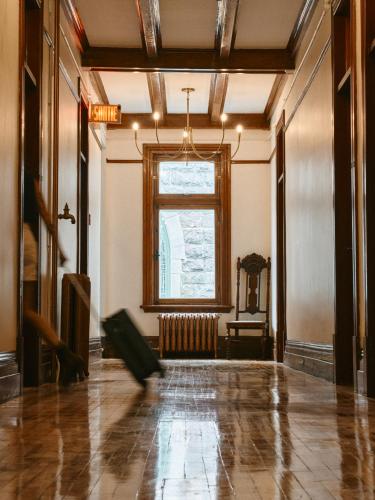 an empty room with a large window and a floor at Hôtel Château Cran Chaud in Saguenay
