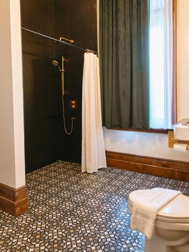 a bathroom with a shower and a toilet at Hôtel Château Cran Chaud in Saguenay