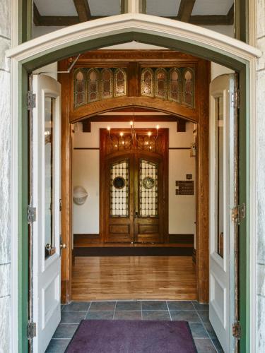 an entrance to a house with a wooden door at Hôtel Château Cran Chaud in Saguenay