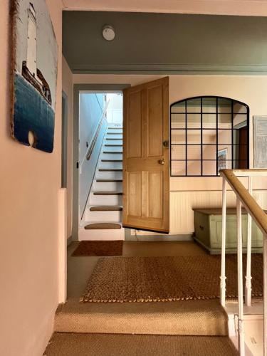 a hallway with a door and stairs in a house at The Blue Loft in Anstruther
