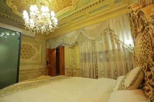 a bedroom with a large bed with a chandelier at 梵雅民宿Vanya in Kashgar