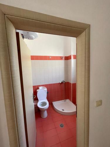 ein Badezimmer mit einem weißen WC und roten Fliesen in der Unterkunft Lilis Apartments Sea view in Sarandë