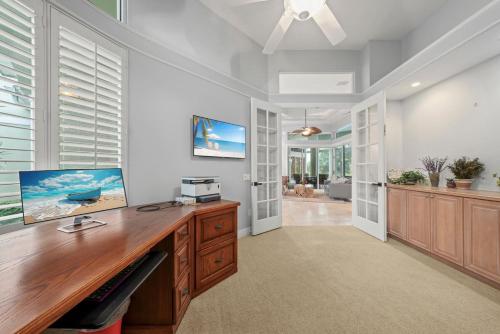 a home office with a wooden desk and windows at Sanctuary Chateau in Sanibel