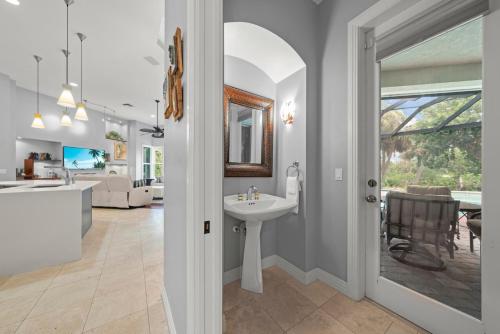 a bathroom with a sink and a living room at Sanctuary Chateau in Sanibel