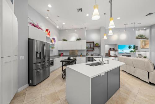 a kitchen and living room with white cabinets and a refrigerator at Sanctuary Chateau in Sanibel