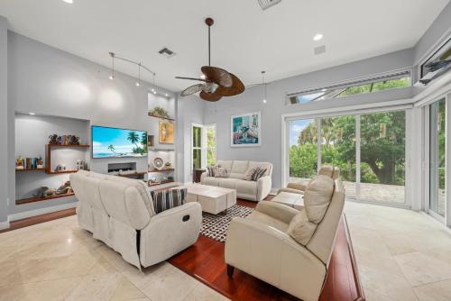 a living room with white furniture and a large window at Sanctuary Chateau in Sanibel