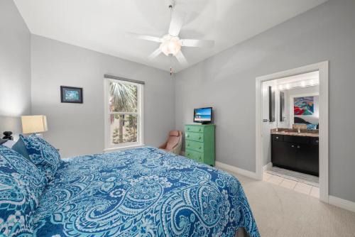 a bedroom with a blue bed and a ceiling fan at Sanctuary Chateau in Sanibel