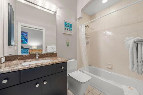 a bathroom with a sink and a toilet and a tub at Sanctuary Chateau in Sanibel