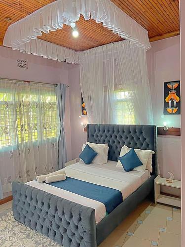 a bedroom with a large blue bed with blue pillows at Homely apartments 4 in Kisumu