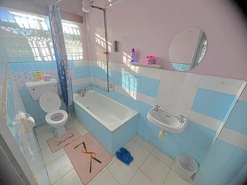 a bathroom with a toilet and a sink and a shower at Homely apartments 4 in Kisumu