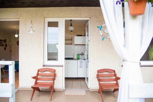 a room with two chairs and a kitchen at Cała NAPRZÓD in Władysławowo