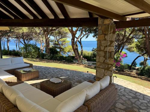 a patio with white couches and a view of the ocean at Villa Star in Capo D'Arco