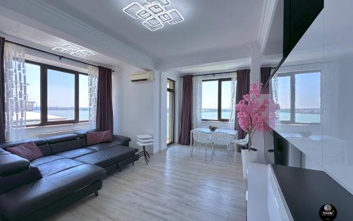 una sala de estar con un sofá y una mesa en Deluxe Nicolle Solid Residence Mamaia, en Mamaia