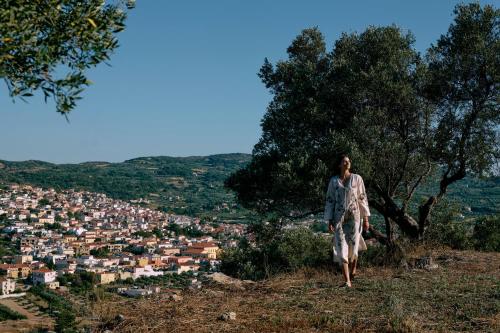 a woman walking on a hill overlooking a city at Arcasa Villas Collection by Omilos Hotels in Archanes