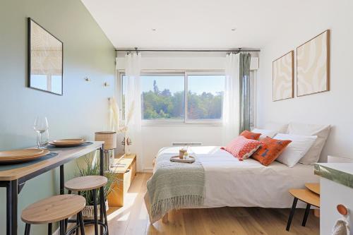 a bedroom with a bed and a table with stools at Le studio de Gargantua in Dardilly