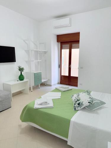 ソレントにあるMaison Intarsioの緑の毛布が掛けられた大きなベッドのある白い部屋