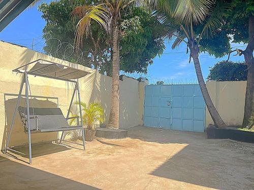 a chair under a canopy next to two palm trees at Homely apartments 4 in Kisumu