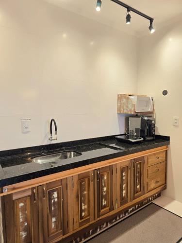 a kitchen with a sink and a microwave on a counter at Navega Hostel in Navegantes