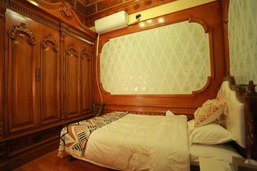 a bedroom with a bed and a large window at 梵雅民宿Vanya in Kashgar