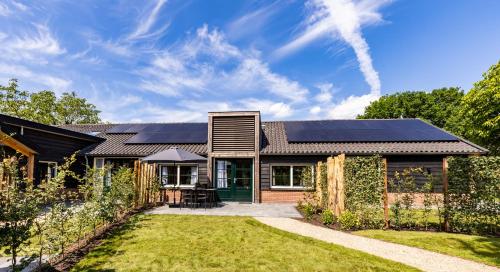 a house with solar panels on the roof at Valkse Hoeve met Hottub | 4 personen in Otterlo